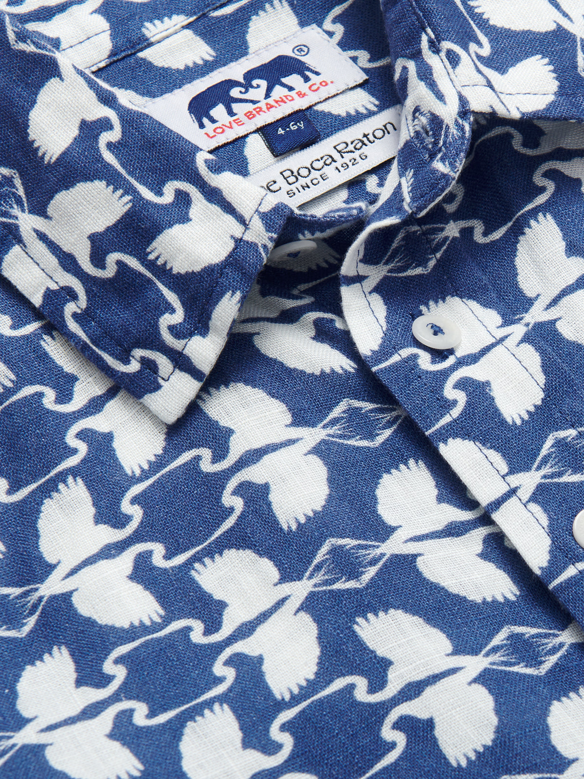 Boys White Heron Abaco Linen Shirt with white heron print on a deep blue background, designed by LOVE BRAND & Co. for The Boca Raton.