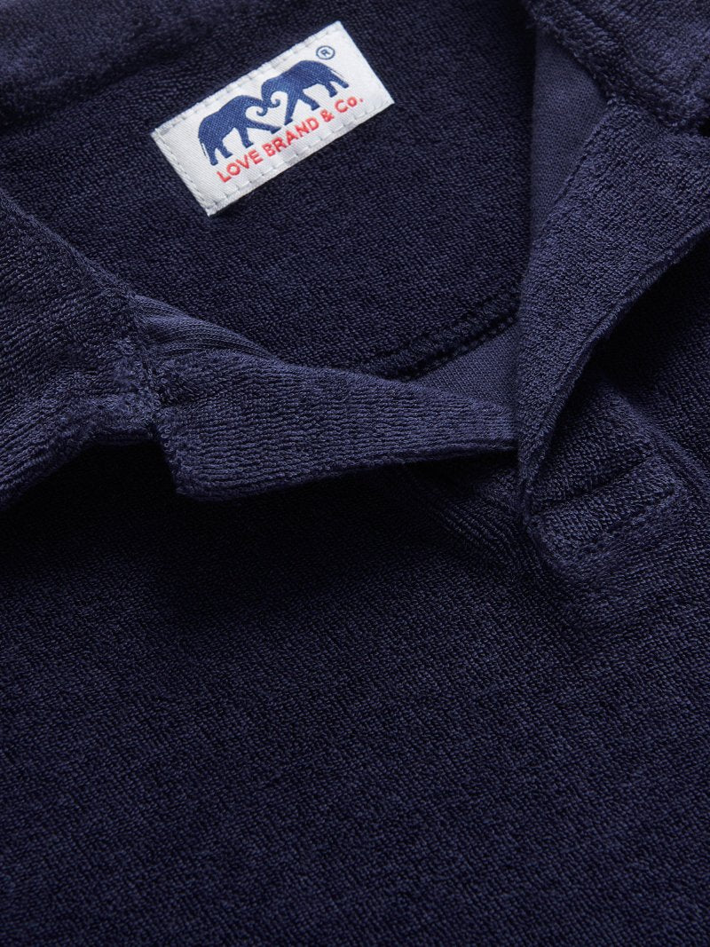 Close-up view of Kids Navy Blue Powell Terry Polo. Blue terry towelling polo shirt for children.