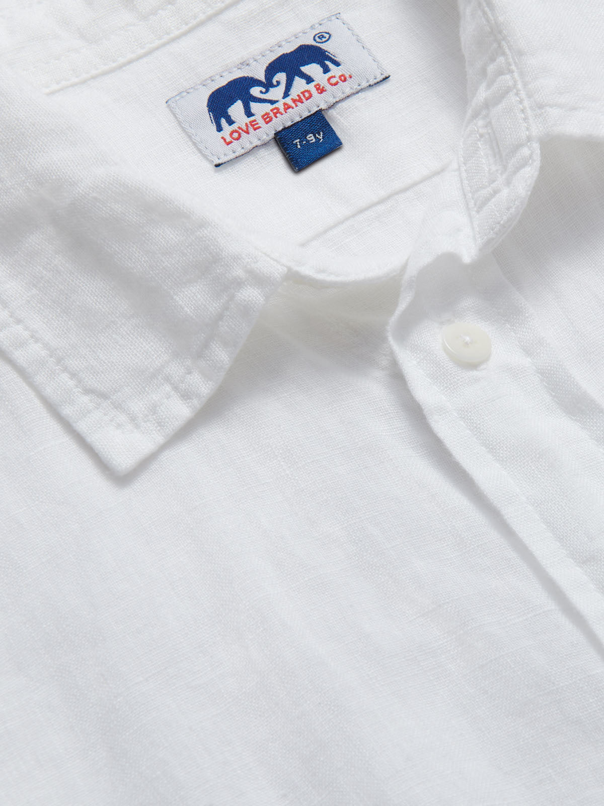 Close-up of Kids White Abaco Linen Shirt showing button-down collar and brand tag.