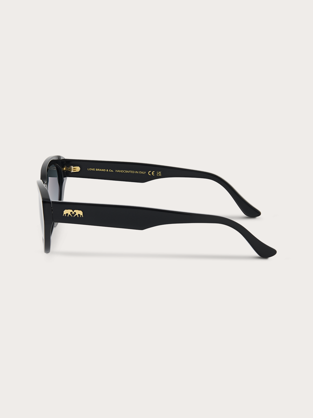 Side view of black cat eye sunglasses with blue lenses and a brand logo on a white background