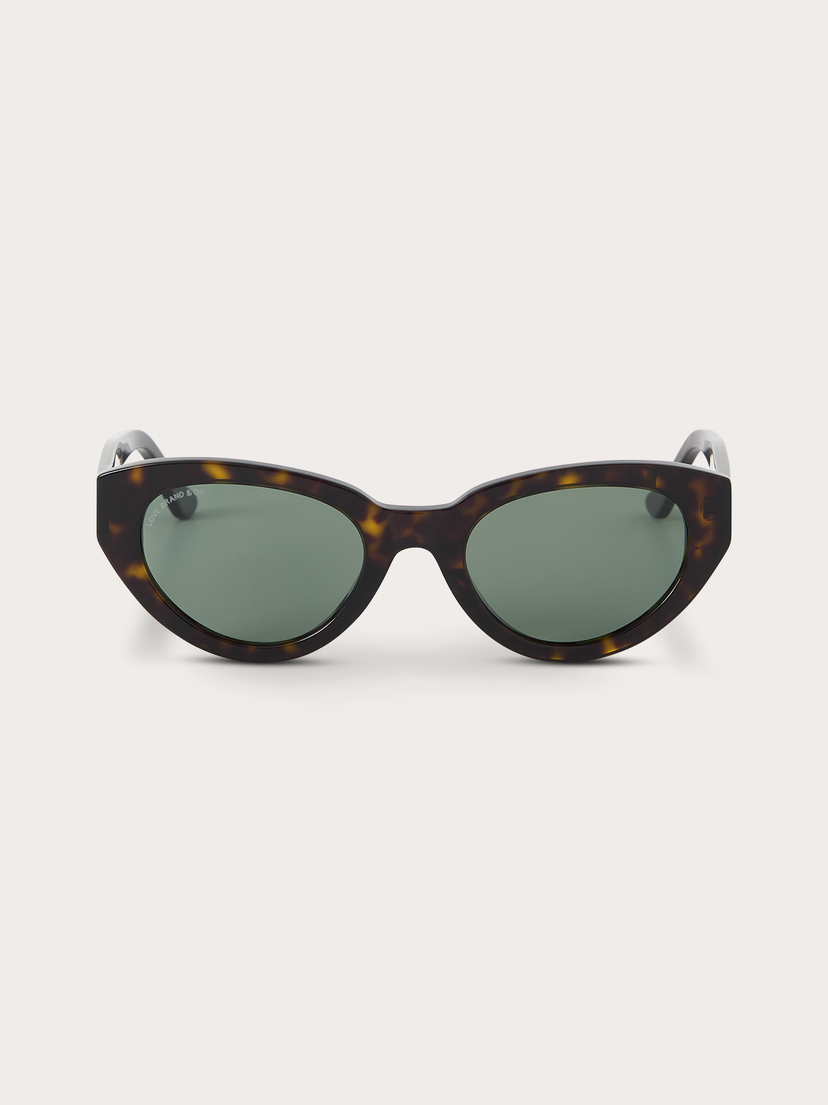 Sunglasses with tortoiseshell frame and green lenses on a white background