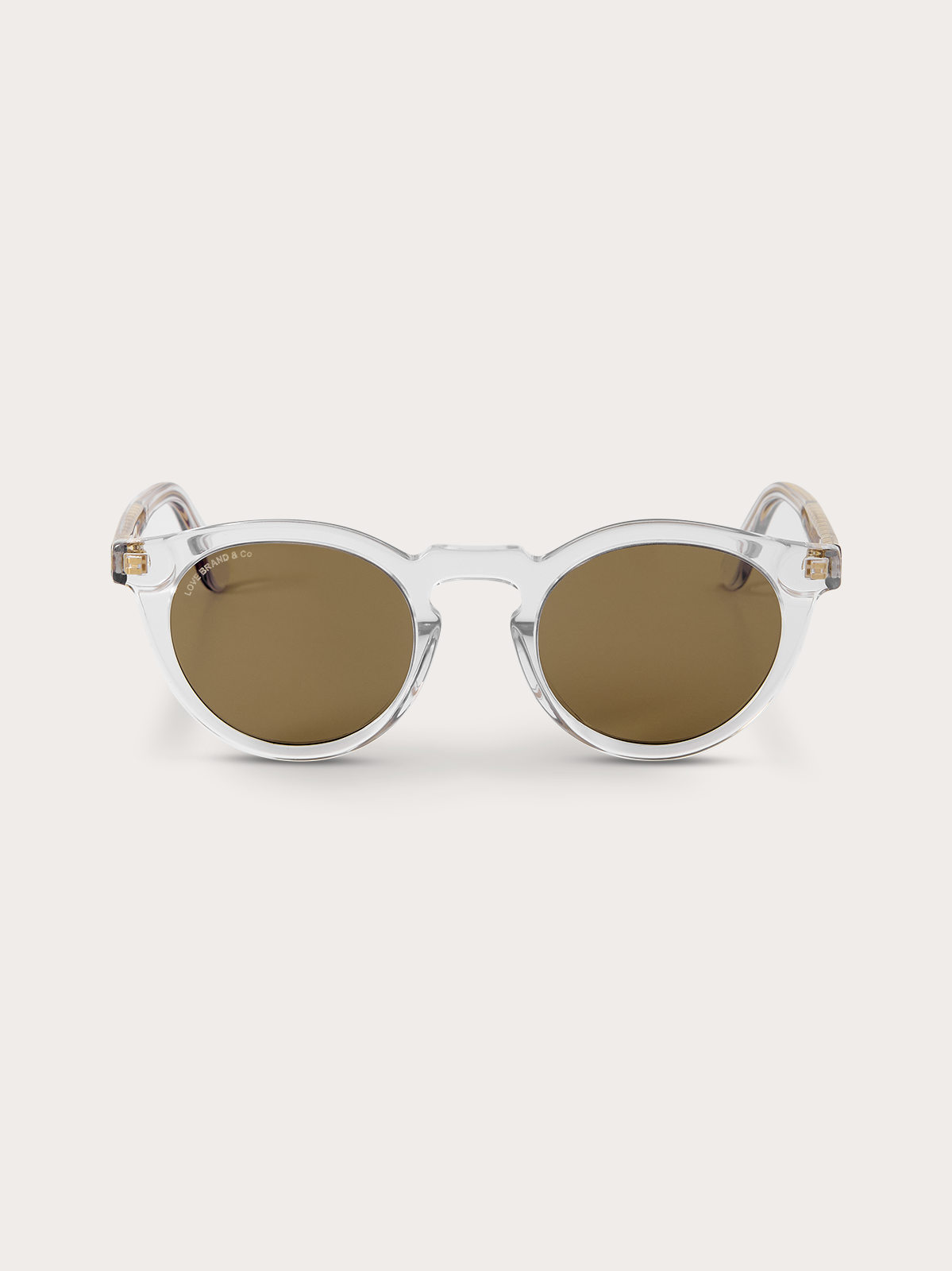 Clear frame sunglasses with brown lenses on a light background