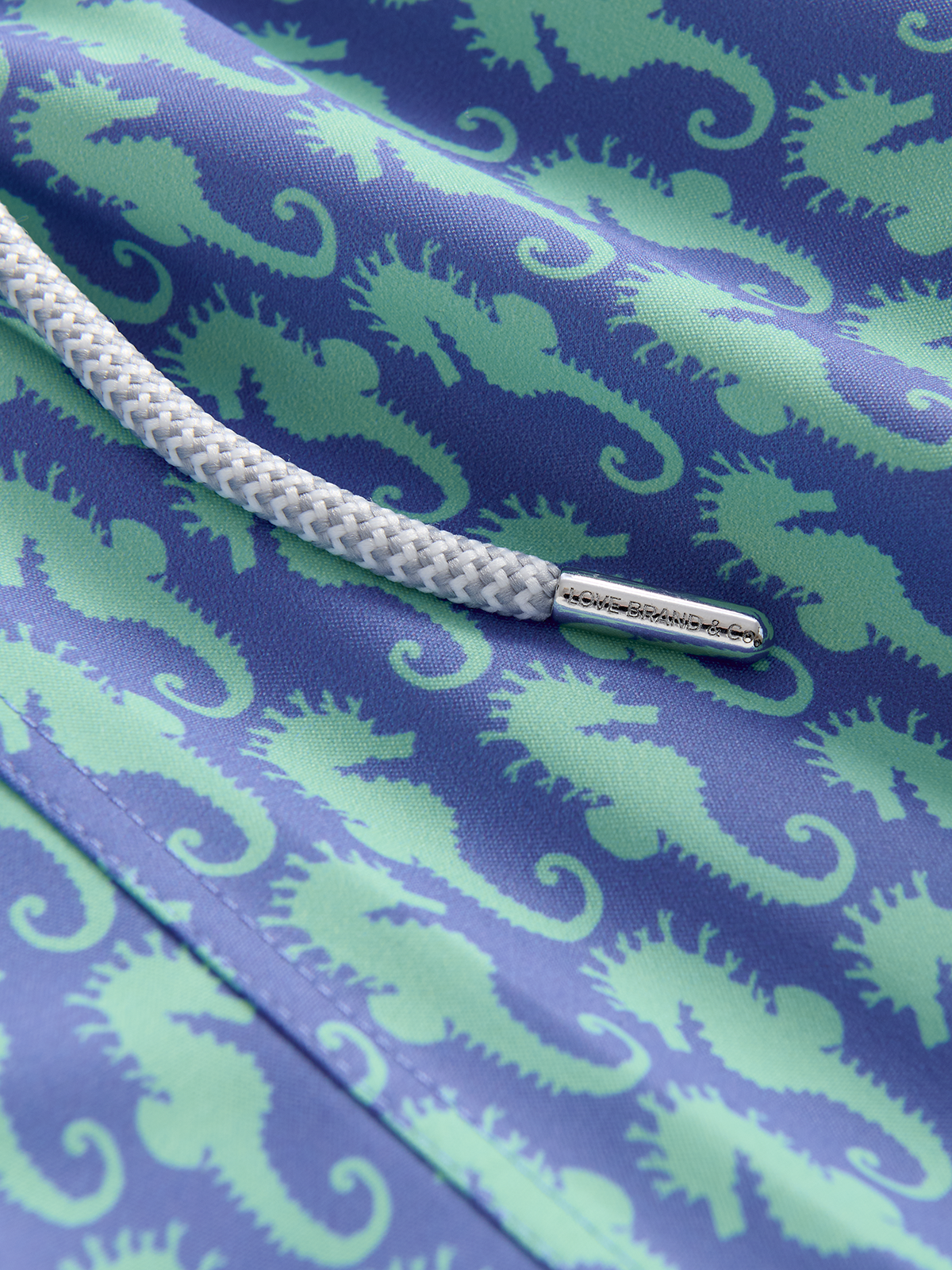 Close-up of a fabric with green seahorse pattern on blue background
