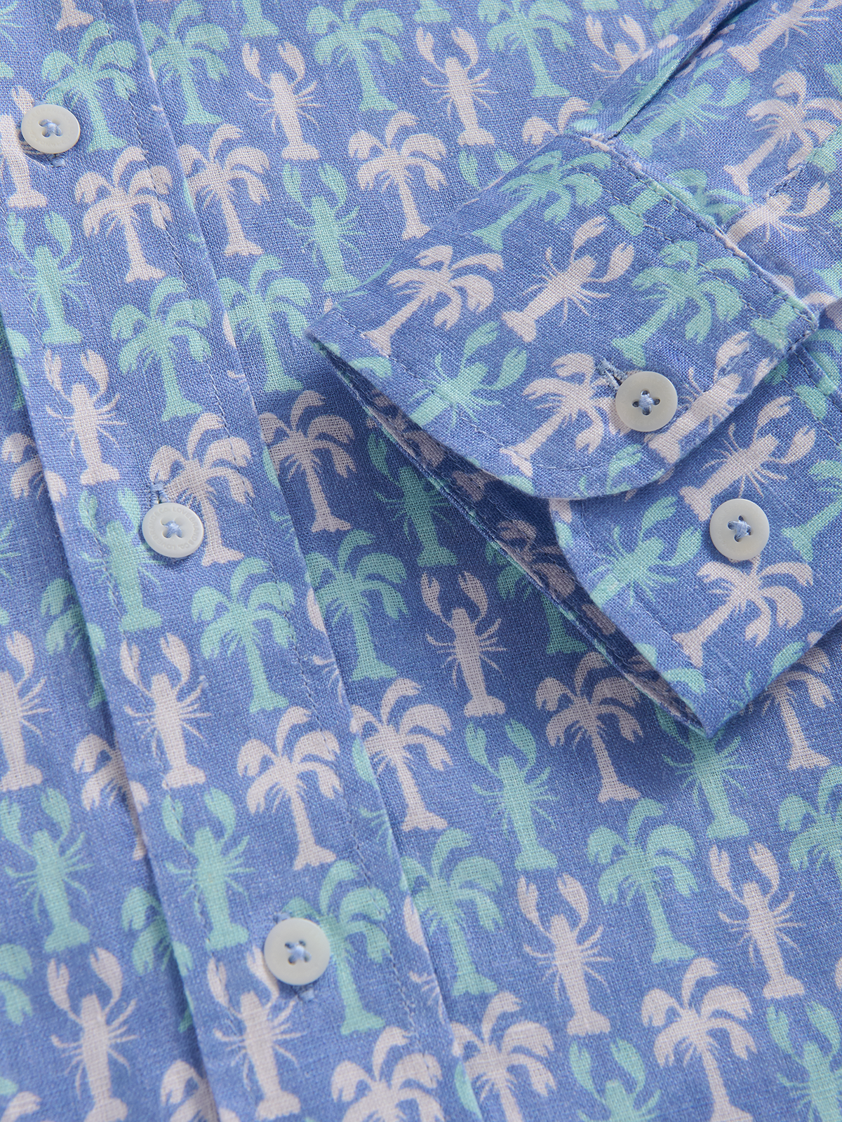 Close-up of a blue shirt with a palm tree and lobster pattern