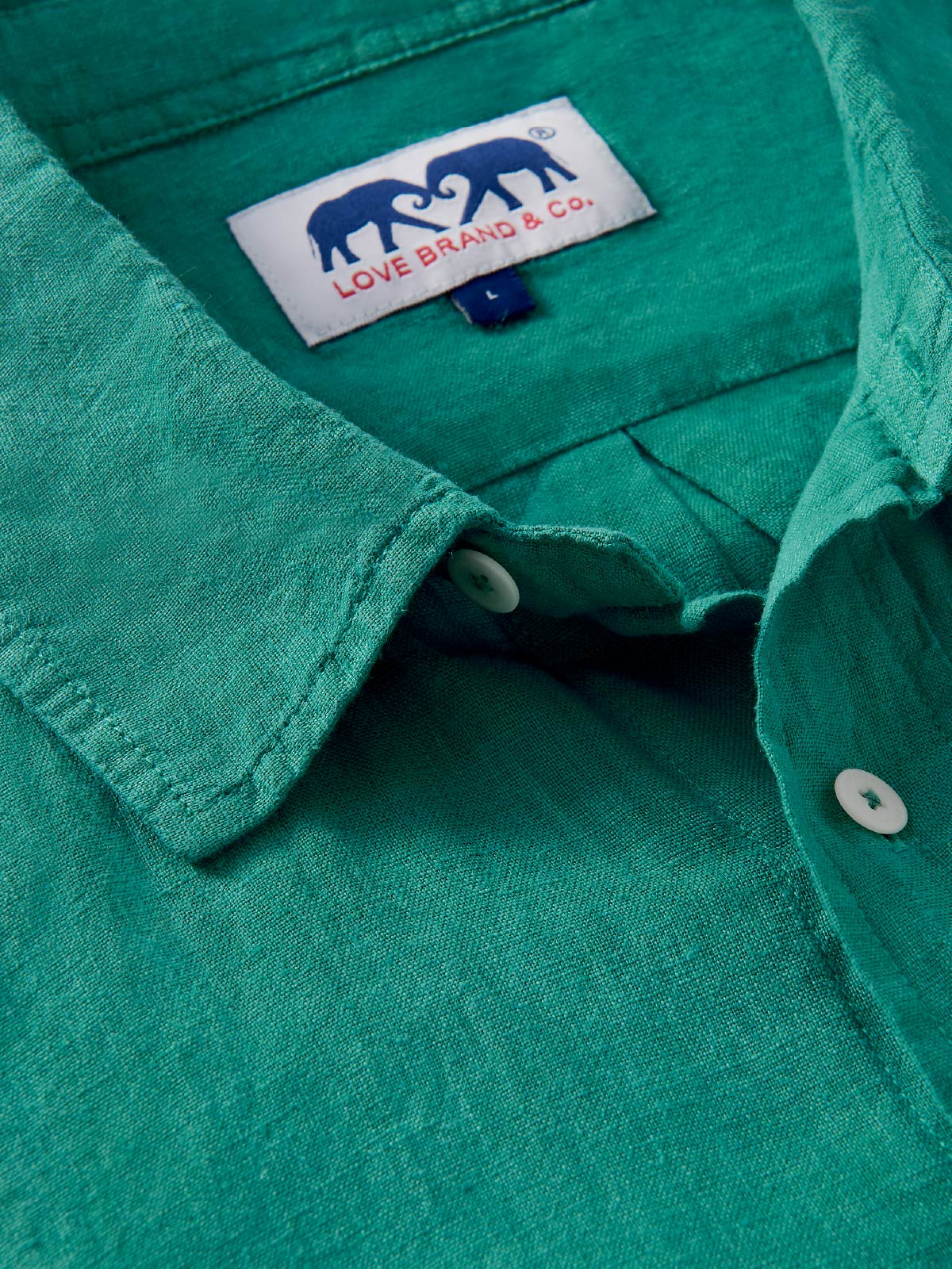 Close-up of a teal shirt with a visible love brand label.