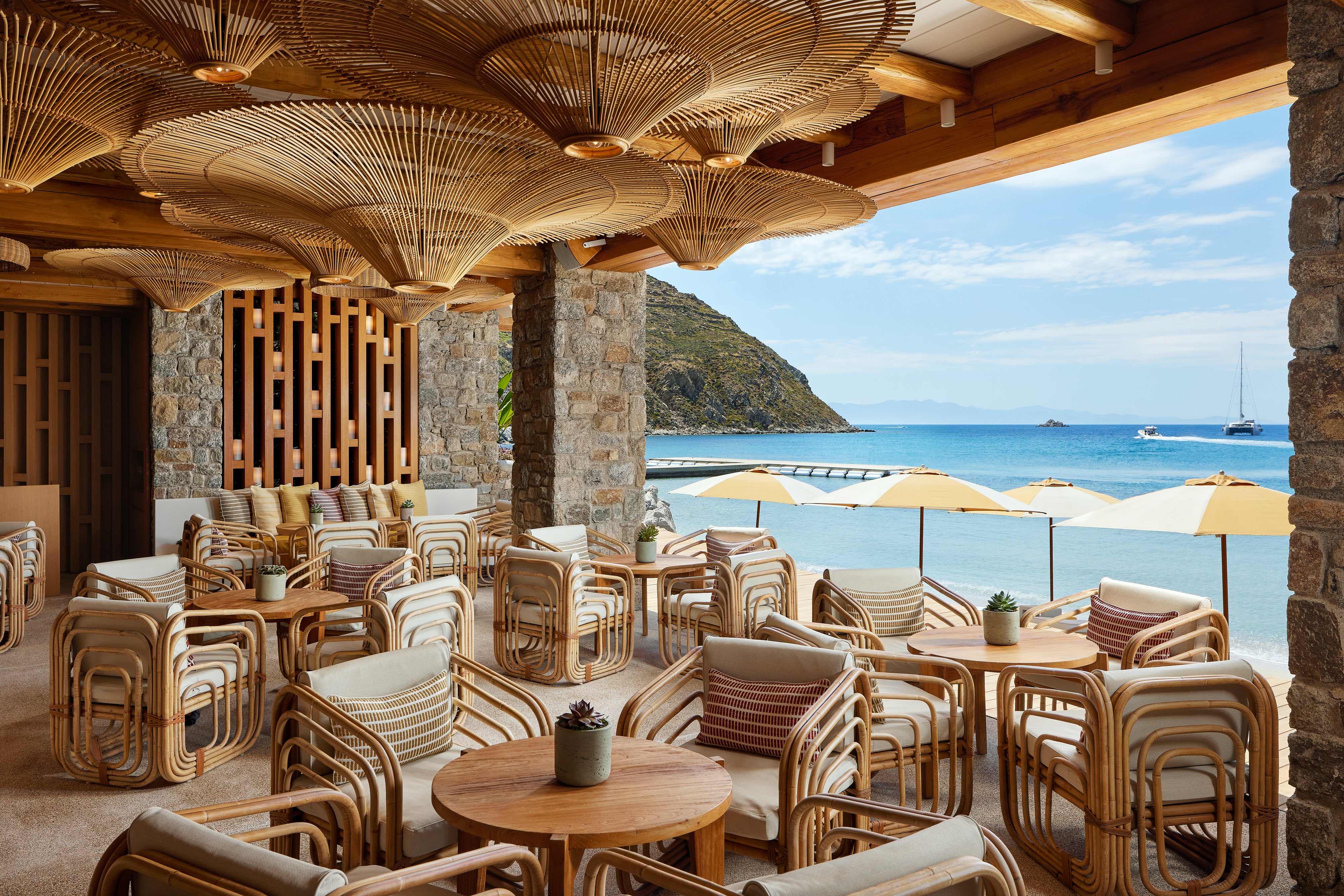 Outdoor seating area of Santa Marina resort with wooden furniture and a view of the ocean