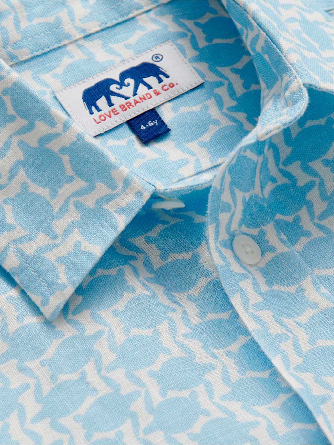 Close-up of a light blue patterned shirt with a subtle turtle pattern and a brand label.