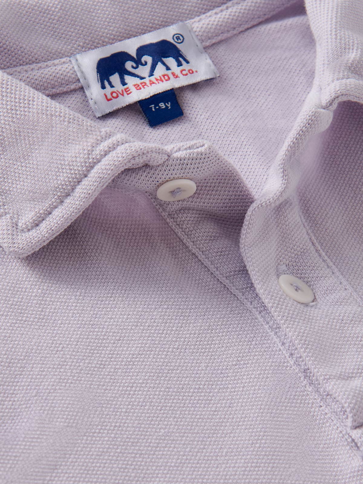 Close-up of childrens polo shirt showing love brand label inside collar.