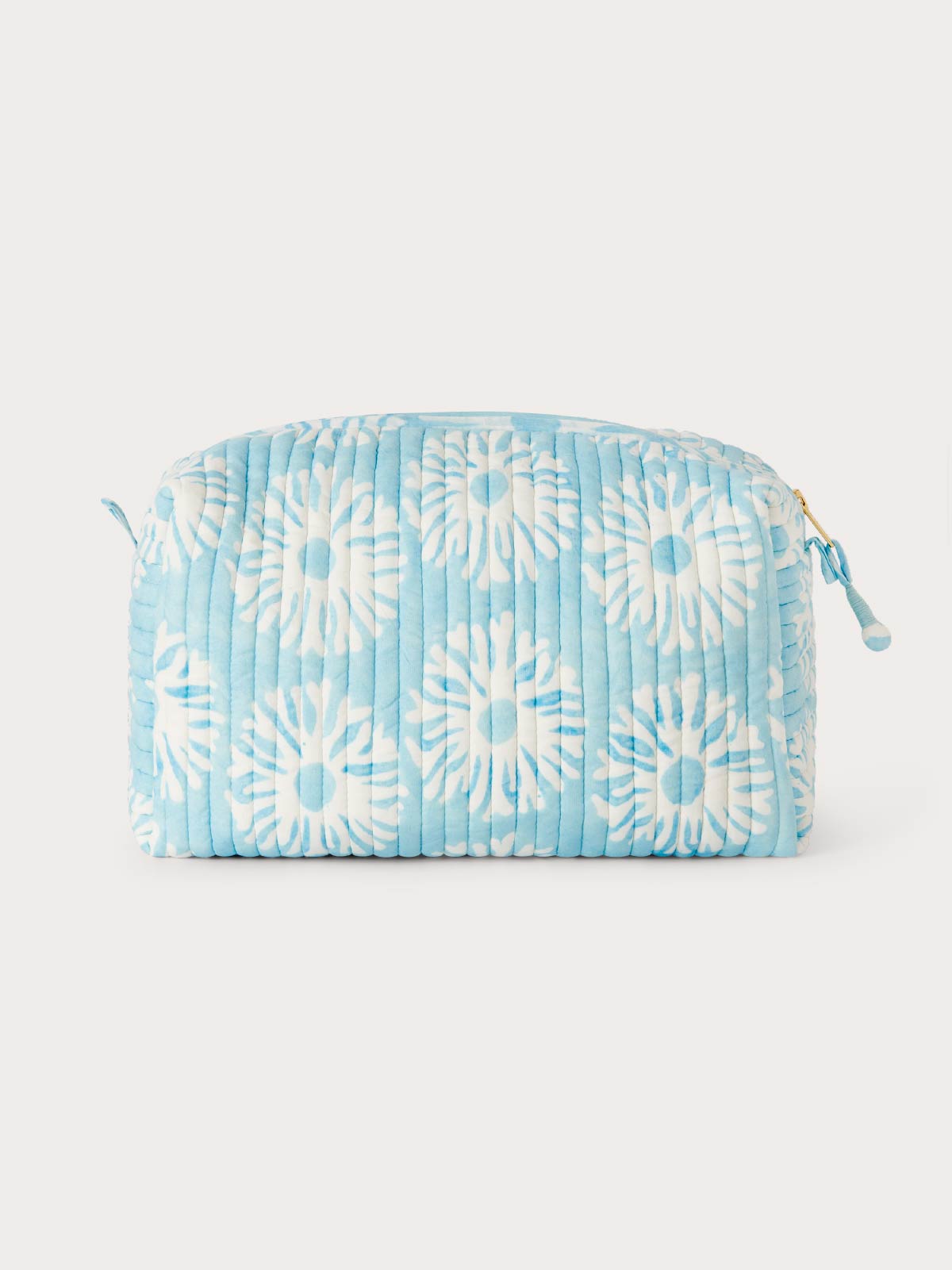 Blue and white quilted wash bag side view.