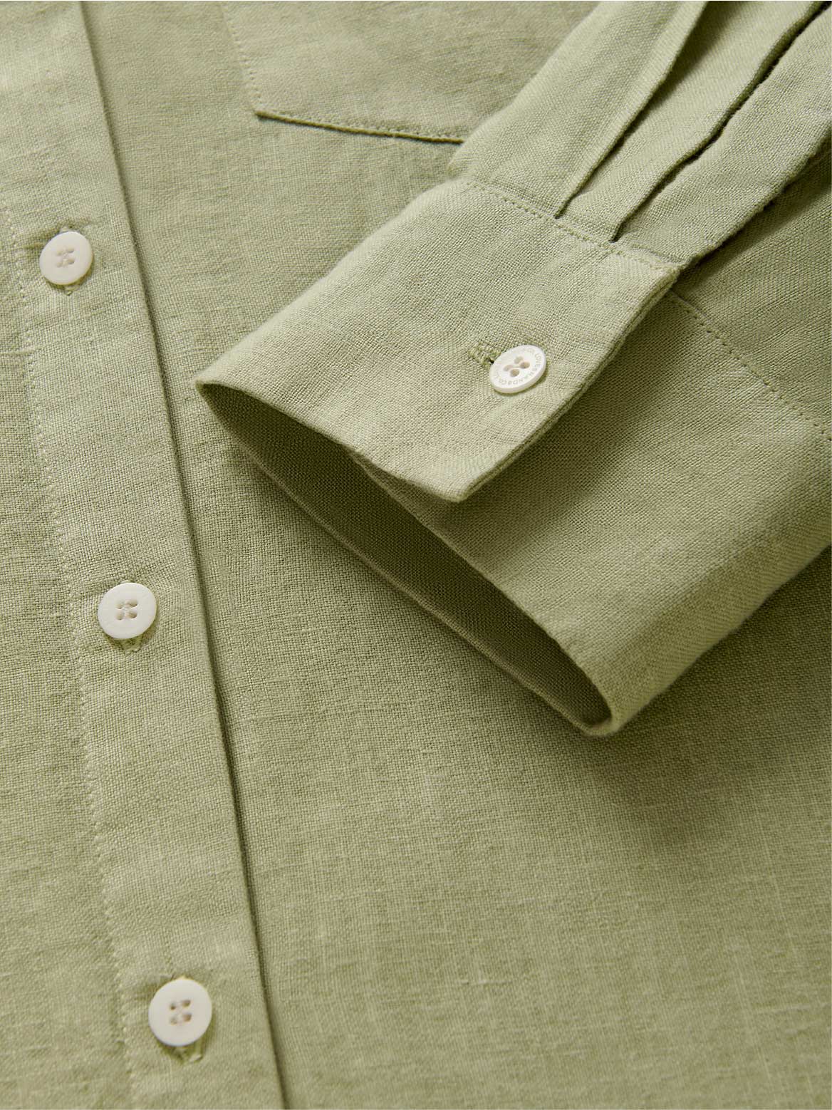 Close-up of a green linen shirt dress cuff.
