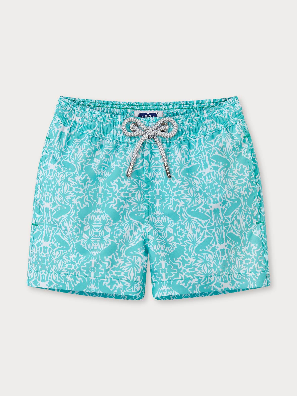 front view of green patterned kids swim shorts with a drawstring waist and pockets.