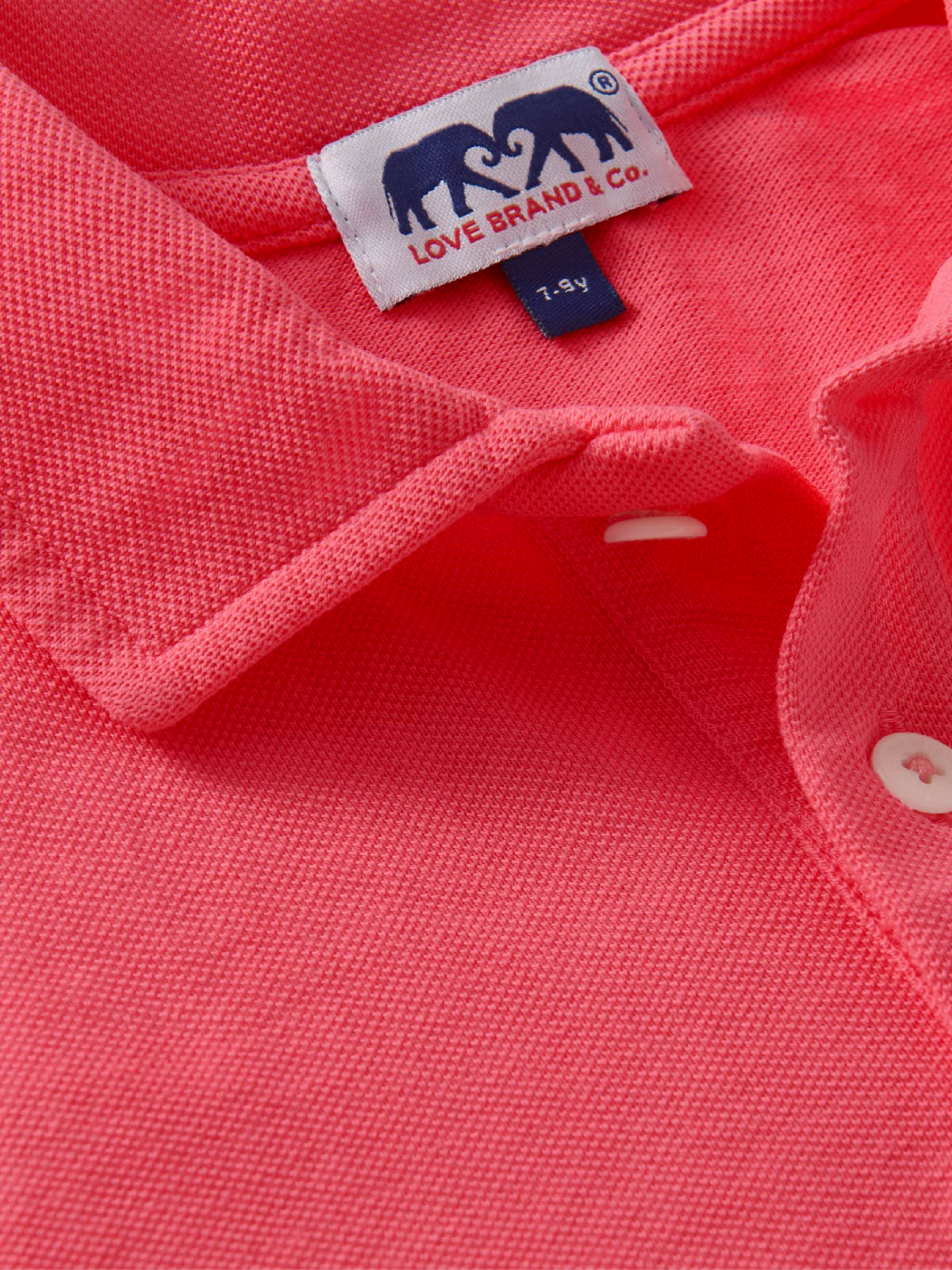 Close-up of a red kids polo shirt with a visible brand label.