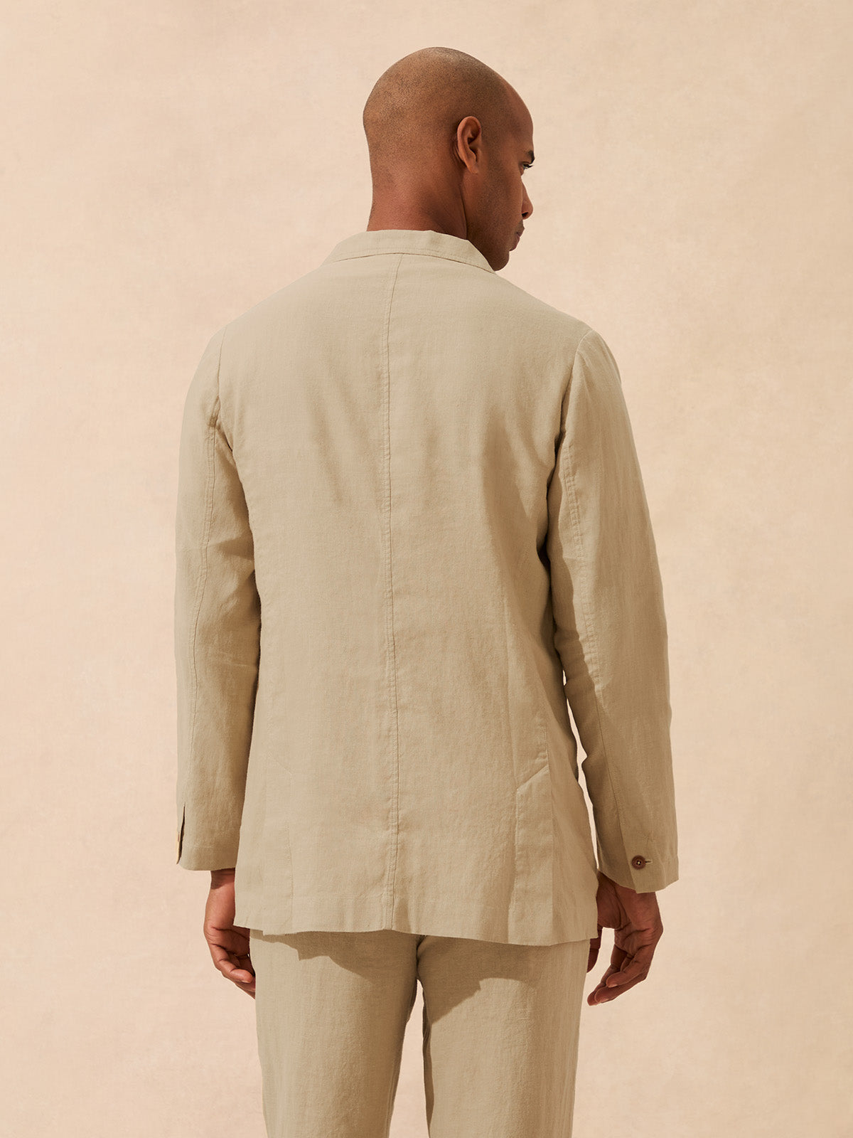Back view of a man wearing a beige linen jacket
