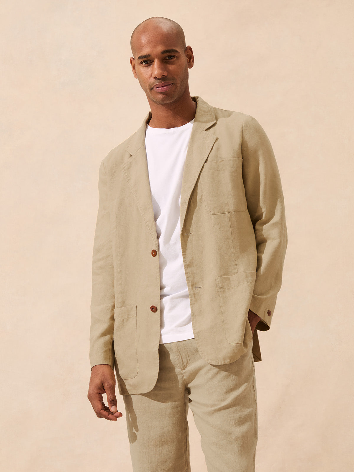 Man wearing a beige blazer over a white t-shirt
