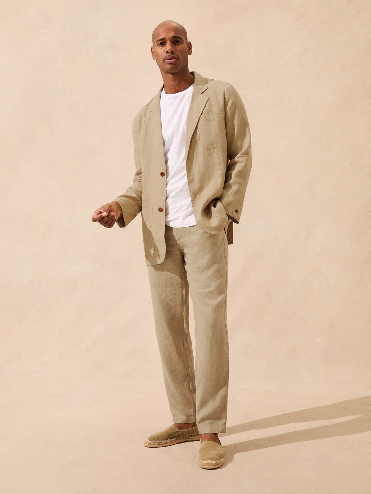 Man wearing a beige linen jacket with matching beige linen trousers