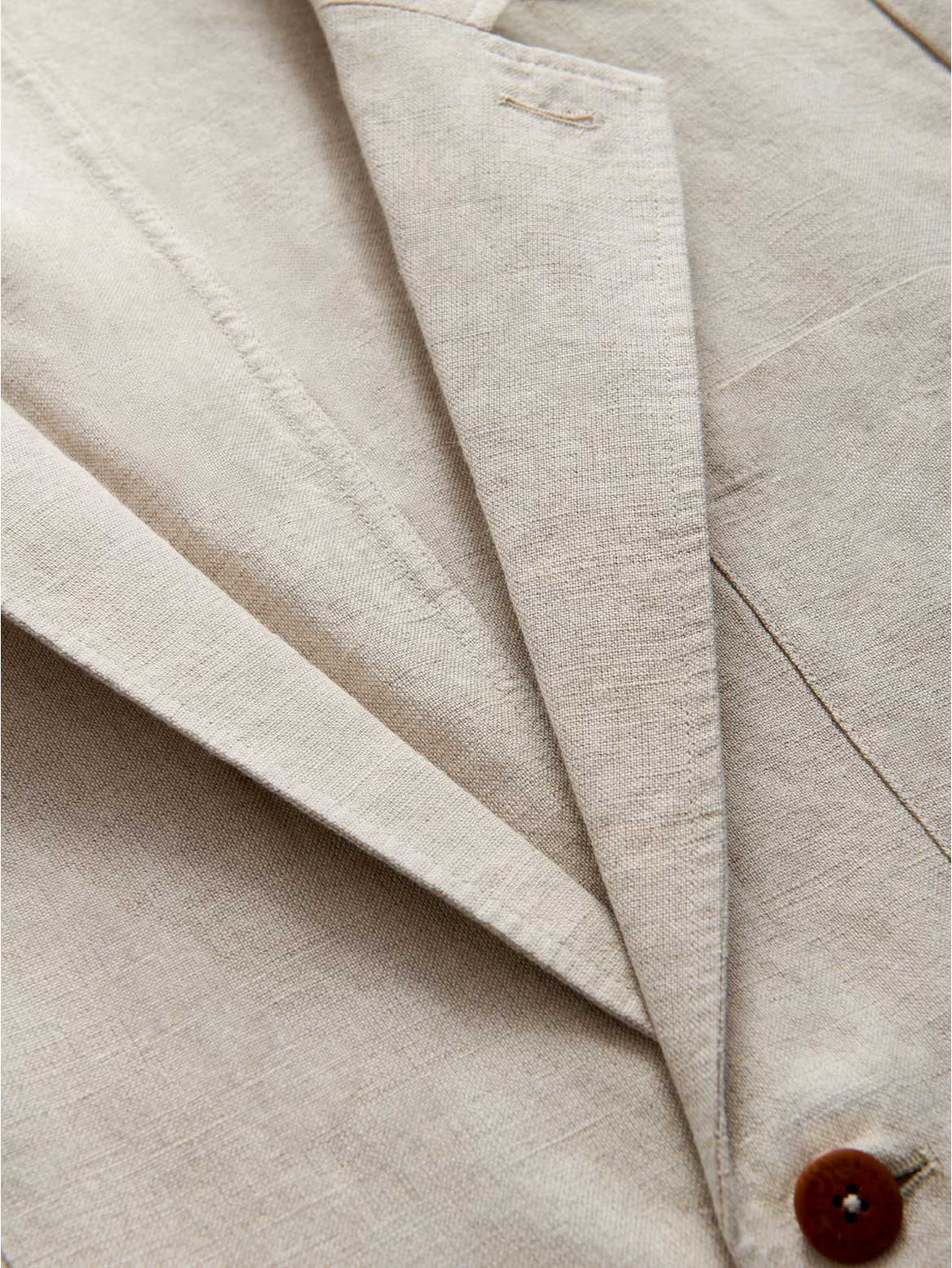 Close-up of the collar of an ecru linen jacket.