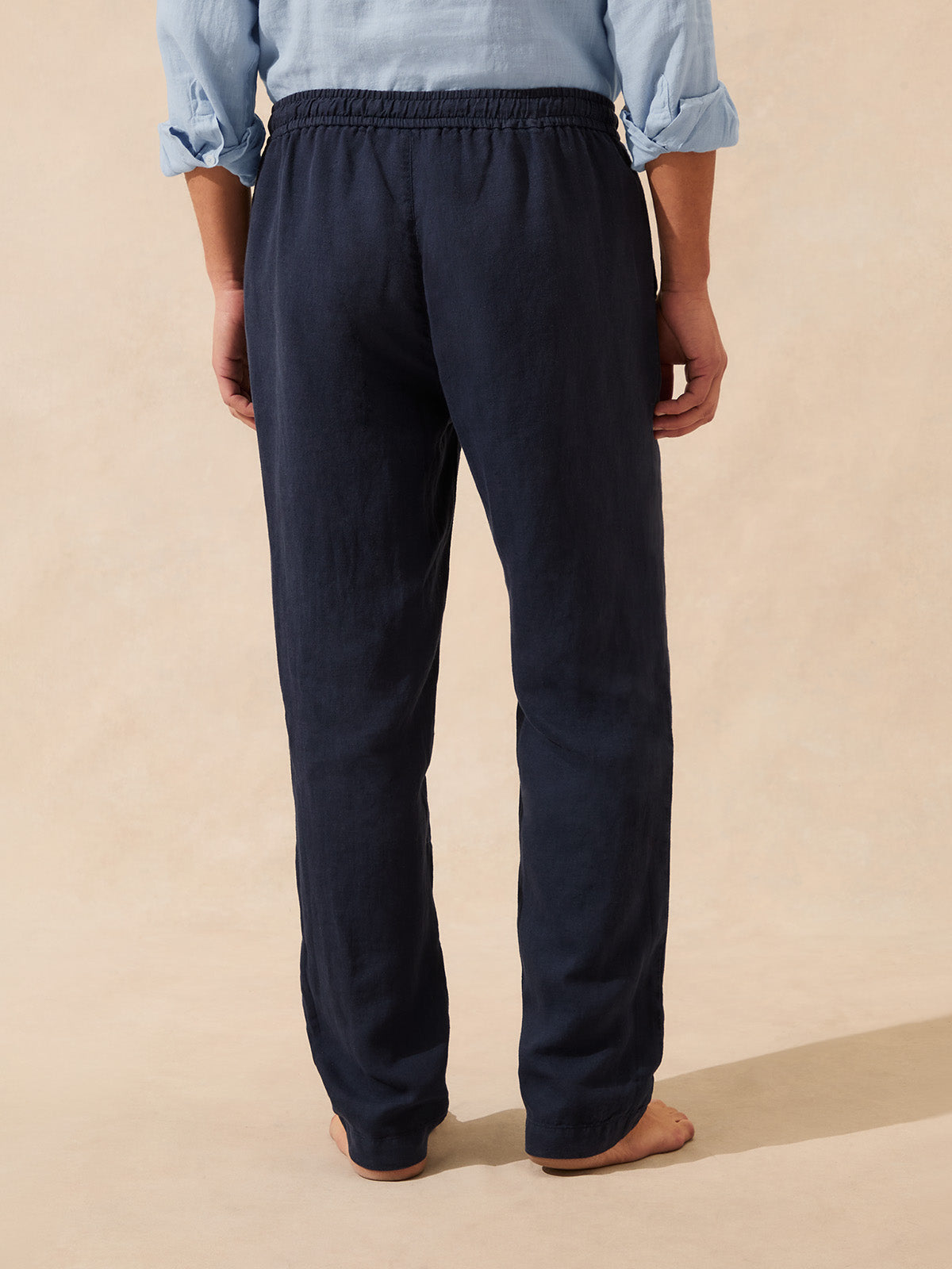 Back view of man wearing navy blue linen trousers