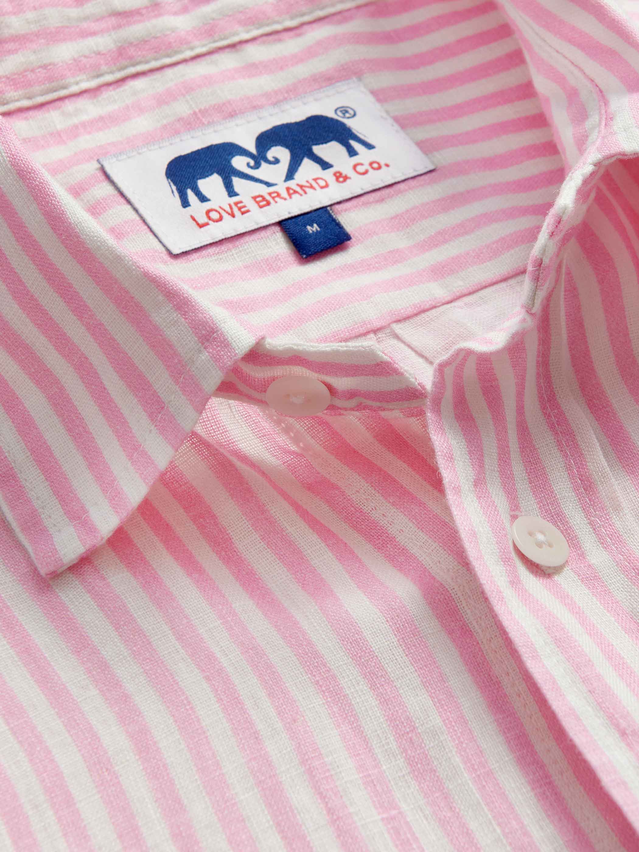 Close-up of a pink and white striped shirt with a love brand label.