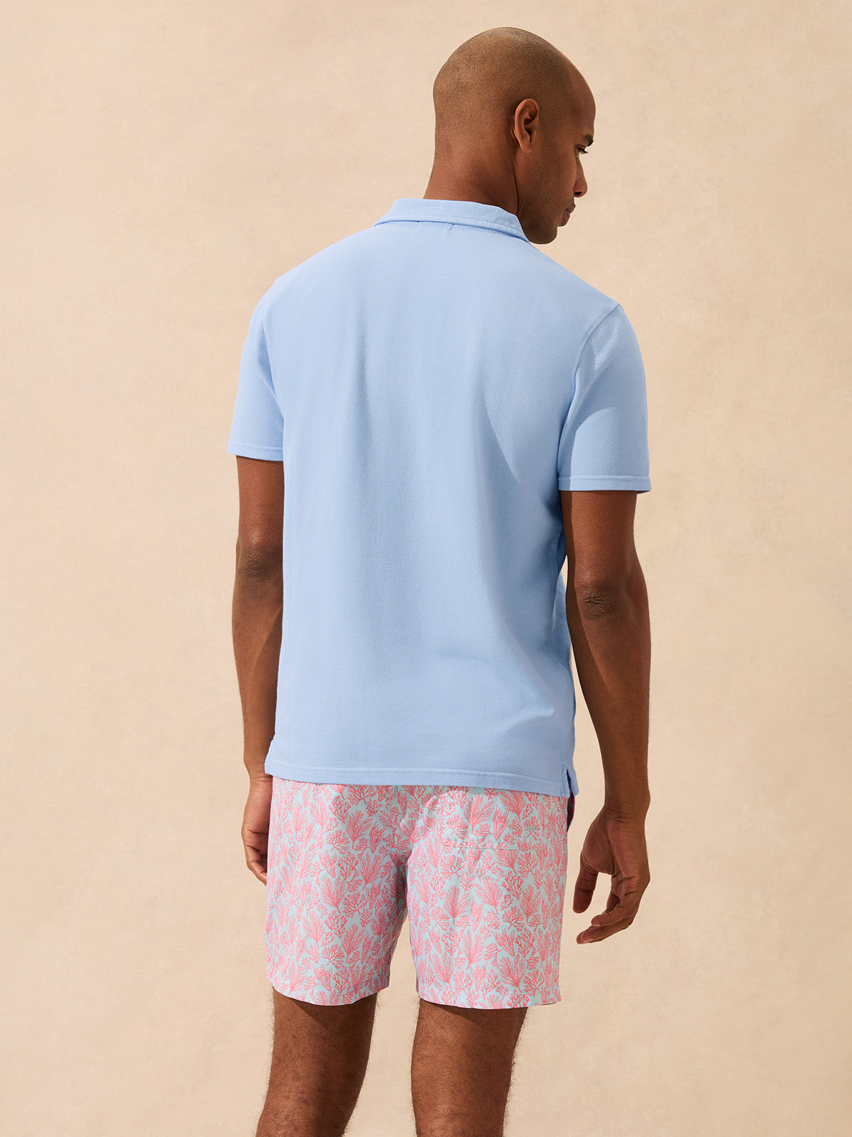Back view of man wearing a light blue polo shirt