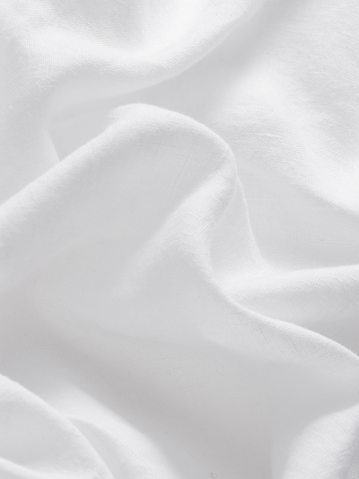 Close-up view of Men's White Joulter Linen Shorts. Classic white shorts for men with a drawstring waist and 2 front pockets in a relaxed fit.
