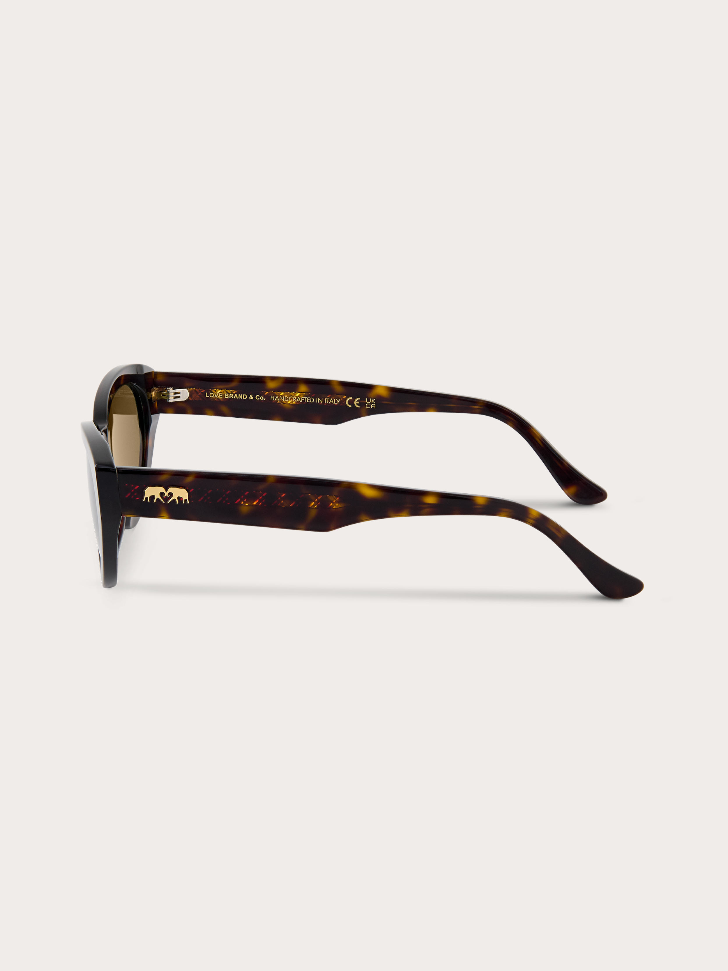 side view of women's tortoiseshell sunglasses with brown lenses showing gold embossed elephant logo