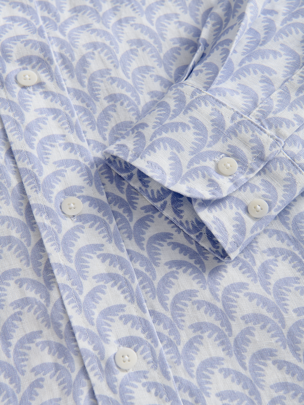 Close-up of a blue and white patterned shirt with buttons.