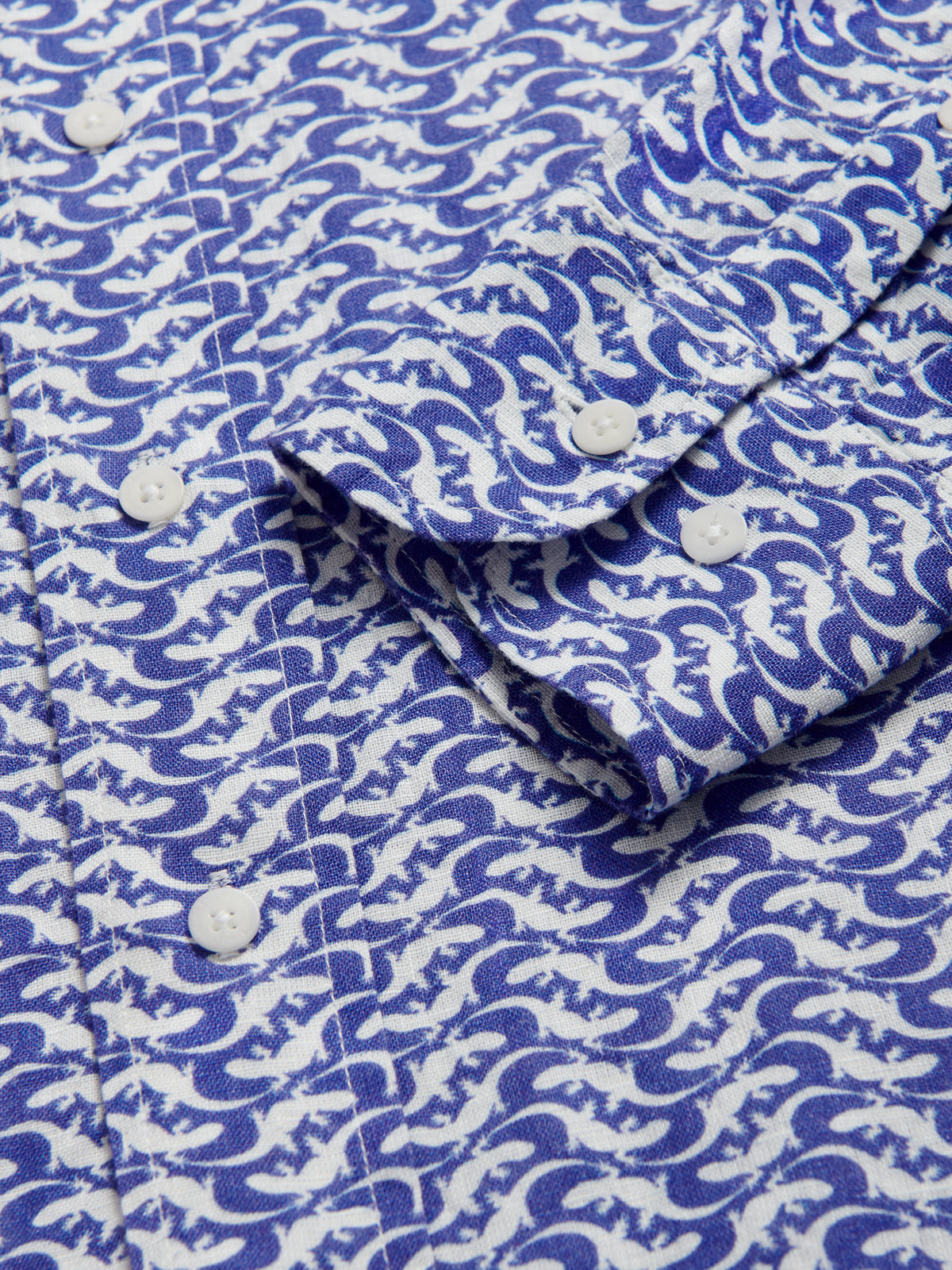 Close-up cuff view of Men's Gecko Island Abaco Linen Shirt. Blue and white patterned shirt with gecko print.