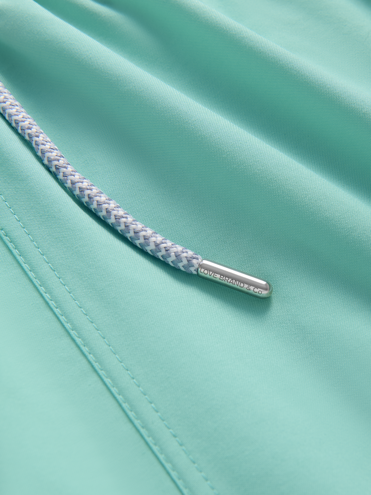 Close-up of a teal fabric with a braided rope handle