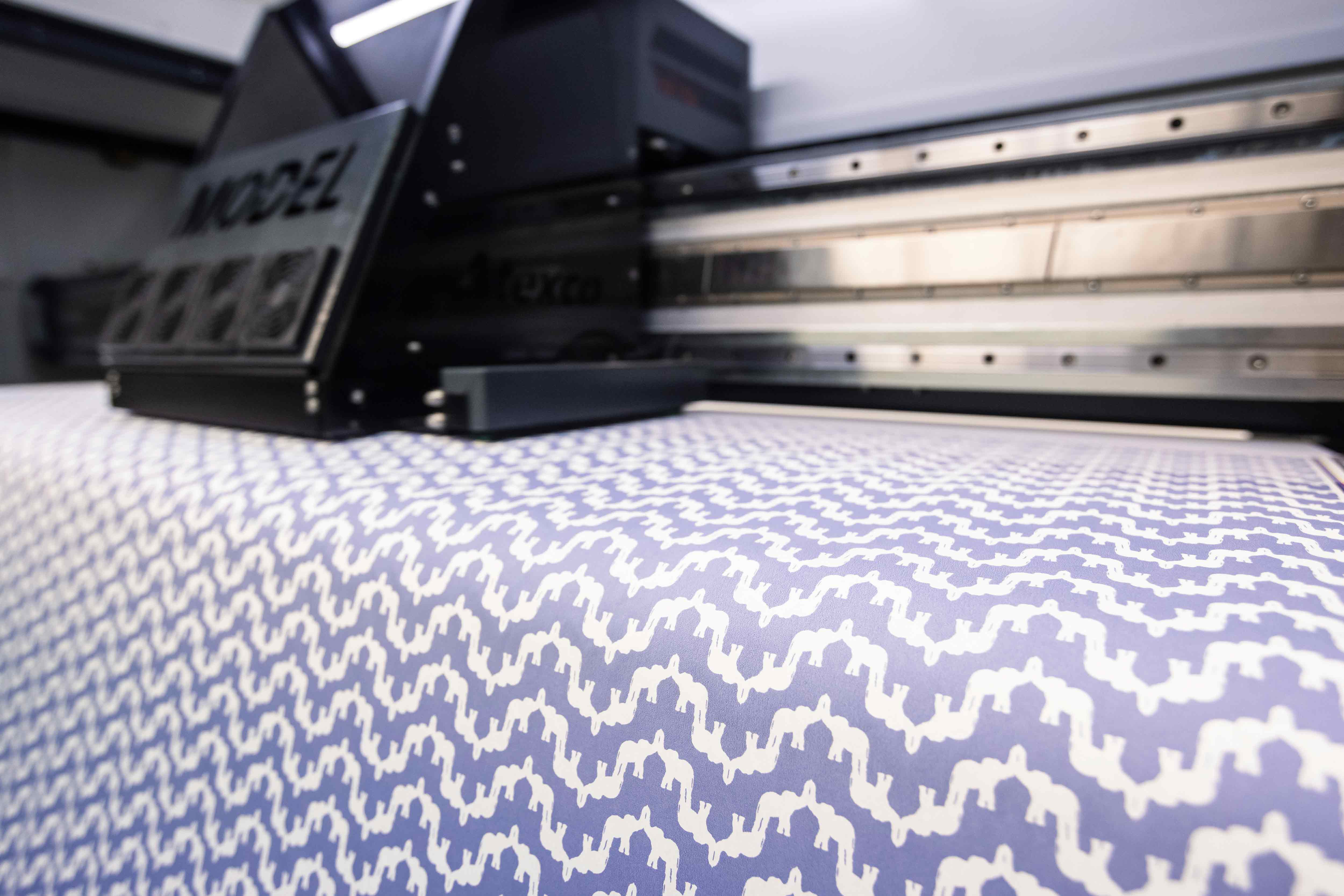 Textile printing machine with a blue and white patterned fabric